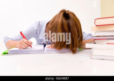 Young woman fell asleep while studying and reading in a library or filling financial reports Stock Photo