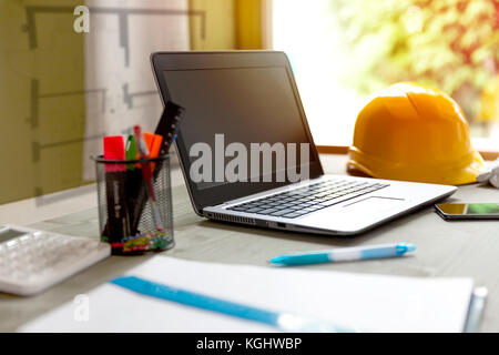 Laptop and contractors helmet in designers/architects office Stock Photo