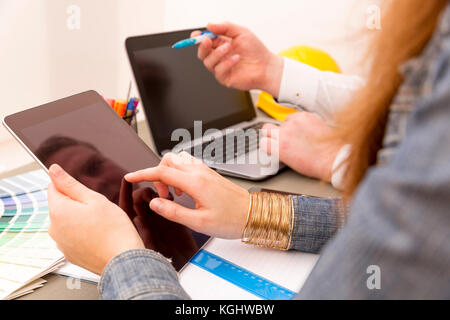 Creative interior design team during brainstorming working on laptop in office Stock Photo