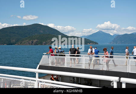 Passengers on the outside deck of a BC Ferry ship travelling in Howe Sound on the way to the Sunshine Coast.  BC Ferry deck in the summer. Stock Photo