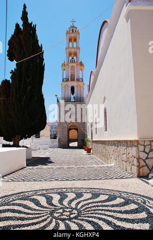 The pebble mosaic courtyard and bell tower of the church of Agios Nikolaos at Emborio on the Greek island of Halki. Stock Photo
