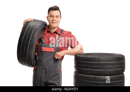 Mechanic leaning on a stack of tires isolated on white background Stock Photo