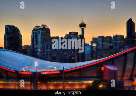 CALGARY, CANADA - MAY 23, 2015: Sunset over Calgary's skyline with the Scotiabank Saddledome in the foreground. The dome with its unique saddle shape  Stock Photo