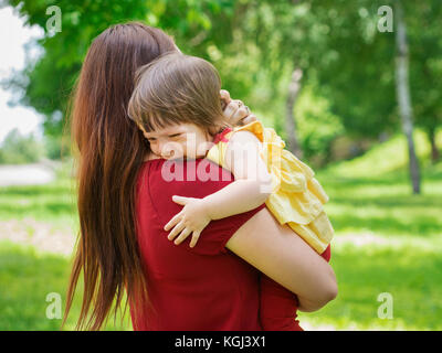 Mother holding crying baby girl with tears Stock Photo
