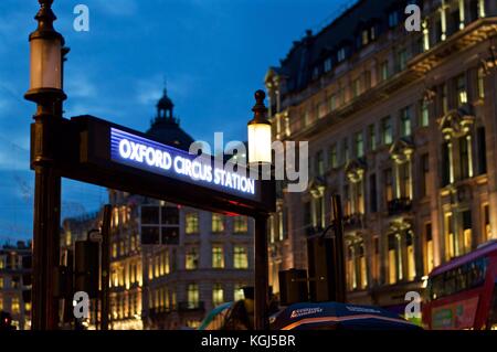 Oxford Circus Tube Station sign with Regent Street buildings in the background, night, London, UK Stock Photo