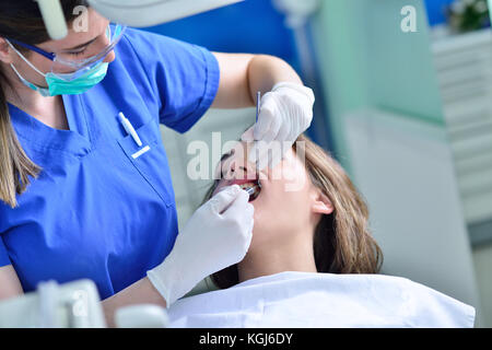 people, medicine, stomatology and health care concept - happy female dentist checking patient girl teeth Stock Photo