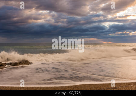 Beautiful sunset on a sandy beach with tide going out. Corfu Greece Stock Photo