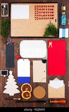 Template with Christmas decorations, various sheets of paper and postal supplies on a wooden background. Top view with copy space Stock Photo