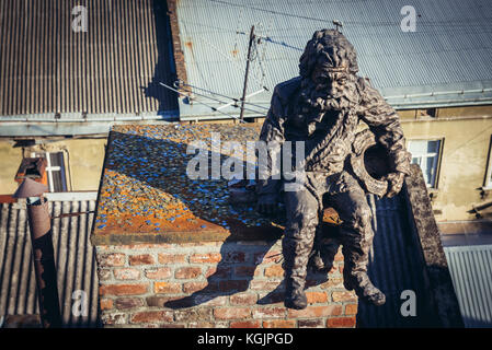 Chimney sweeper sculpture on the roof of famous restaurant House of Legends on the Old Town of Lviv city, largest city in western Ukraine Stock Photo