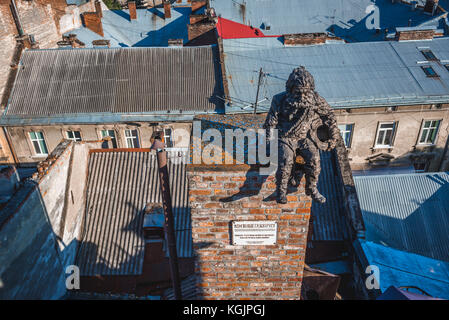 Chimney sweeper sculpture on the roof of famous restaurant House of Legends on the Old Town of Lviv city, largest city in western Ukraine Stock Photo