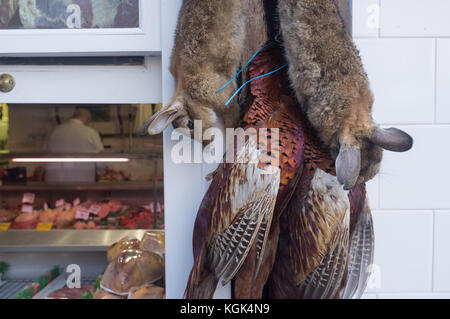 Rabbits and pheasants hanging up outside a traditional English country butchers, Ludlow, Shropshire, UK Stock Photo