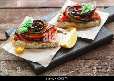 Tapas with baked aubergines and peppers on wooden board, rustic style Stock Photo