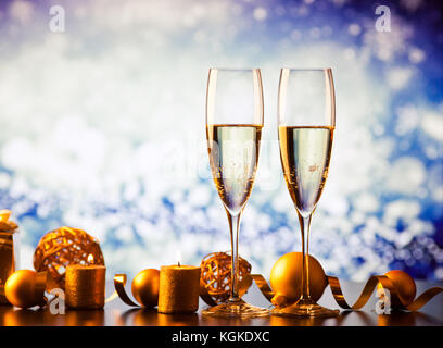 two champagne glasses against holiday lights and fireworks - new year celebration Stock Photo