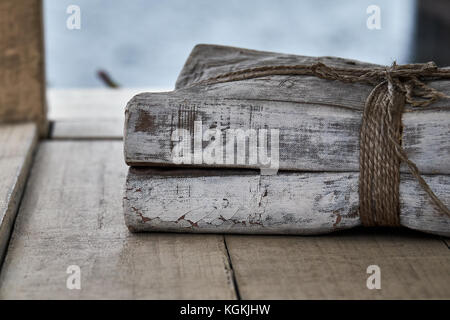 Stack of old tied books on wooden shelf Stock Photo