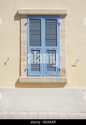 Wooden window shutters - Closed old shuttered weathered wooden window in the Limassol, Cyprus Stock Photo