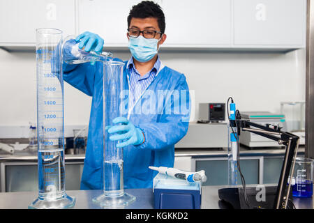 Young male scientist working at laboratory dressed in blue Stock Photo