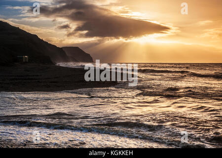 Sunrise on Charmouth beach looking towards Golden Cap. Stock Photo