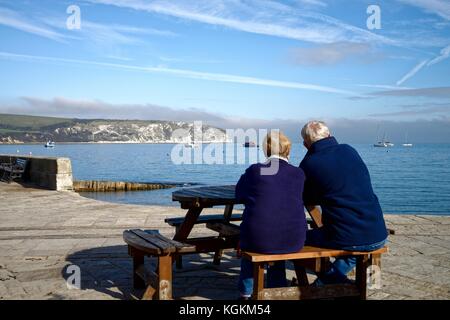 Old couple looking at the view of Swanage Bay Dorset England UK Stock Photo