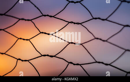 Chain Link Fence at sunset with shallow depth of field and nice colors Stock Photo