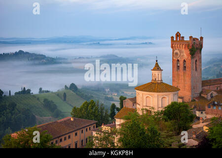 Misty sunrise over Cattedrale di Santa Maria Assunta e di San Genesio and medieval town of San Miniato, Tuscany, Italy Stock Photo