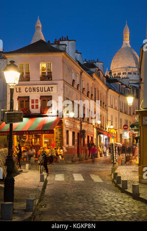 Twilight in the cobblestone streets of Monmartre with Tower of Basilique du Sacre Coeur beyond, Paris France Stock Photo