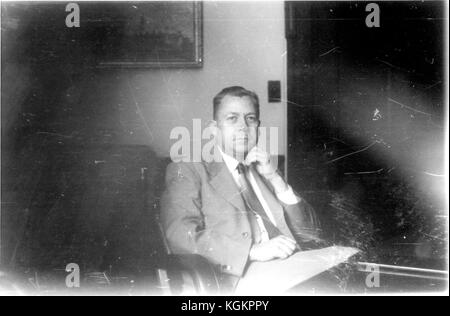 Portrait of Henry George Homer Halvorson, Director of the Library at the Johns Hopkins University in 1947, seated in his office wearing a suit, full face, waist up, hand resting on chin, with a large piece of paper on his lap, around 50 years old, Baltimore, Maryland, 1948. () Stock Photo