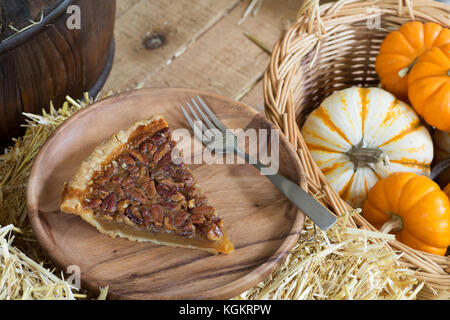Slice of pecan pie with autumn gourds Stock Photo