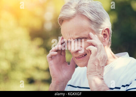 Cheerless elderly man suffering from the headache Stock Photo