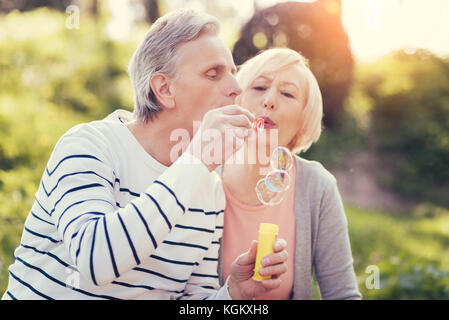 Handsome senior man blowing soap bubbles Stock Photo