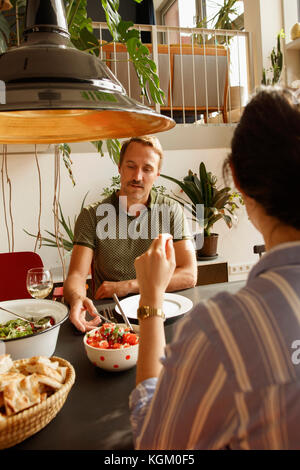 Couple having food at dining table in house Stock Photo
