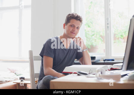 Portrait of handsome young male university student studying at home Stock Photo