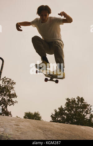 Full length of young man skateboarding at park against clear sky Stock Photo