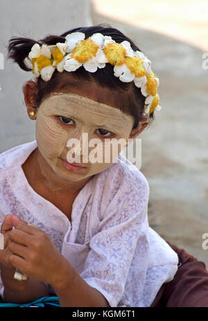 Young girl poses wearing traditional thanaka in Bagan, Myanmar Stock Photo