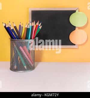 Black Chalk board with Sticky notes and Color pencils Stock Photo