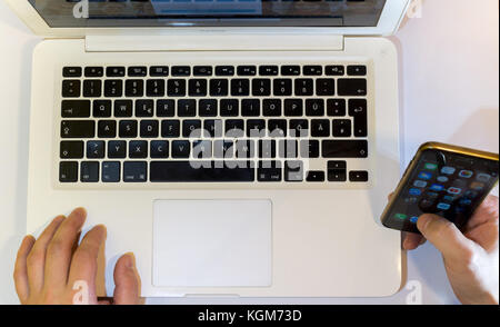 Using mobile Devices Laptop and Mobile phone top view, Vienna Austria 9.11.2017 Stock Photo