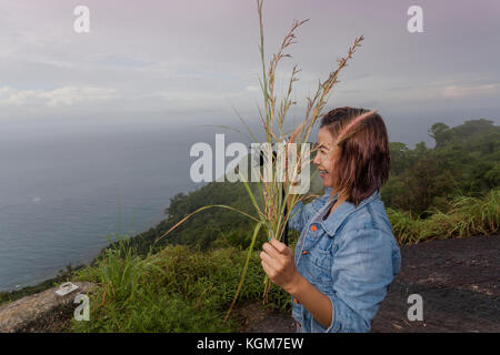 a lady drinking coffee on the highest viewpoint name Pha Hin Dum. on Pha Hin Dum viewpoint can see around Phuket island. Niharn beach wind turbine Pho Stock Photo