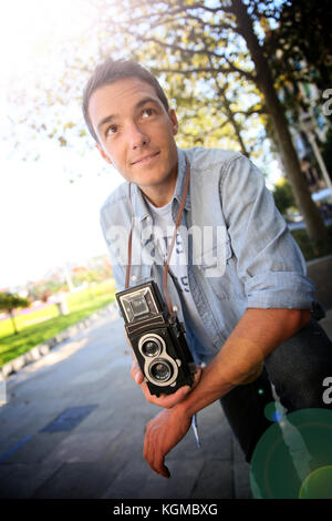 Young man holding vintage camera Stock Photo