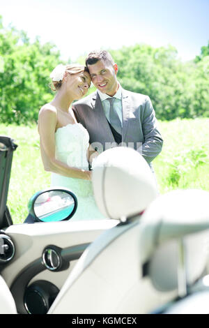 Bride and groom walking towards convertible car Stock Photo - Alamy