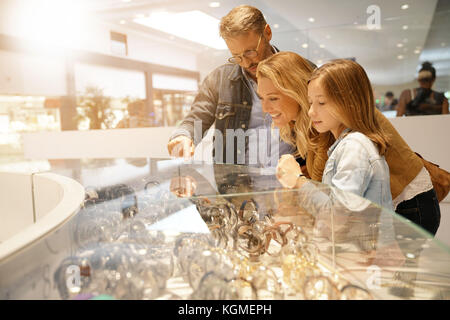 Family in shopping mall looking at jewelry department Stock Photo