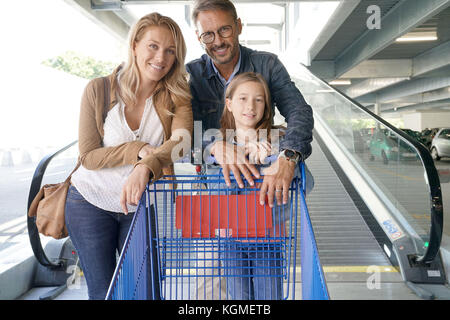 Family going down escalator of shopping mall Stock Photo