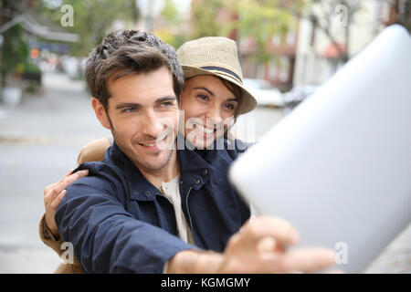 Cheerful couple taking picture with tablet Stock Photo