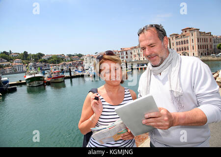 Senior couple using digital tablet to find city tour Stock Photo