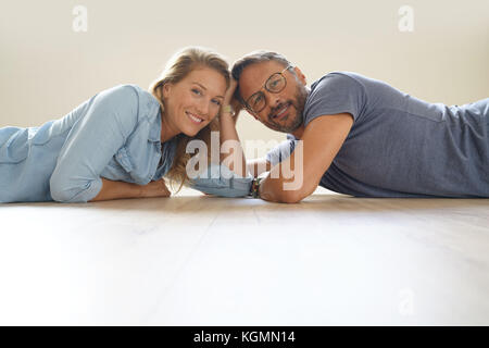 Mature couple laying on floor and looking at camera Stock Photo