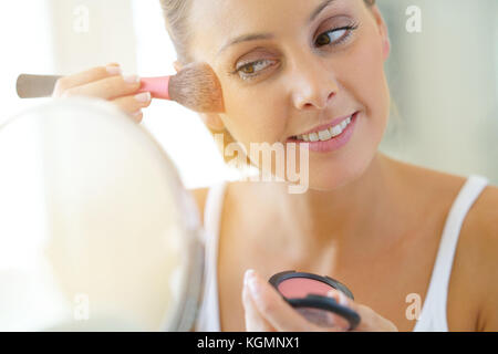 Portrait of beautiful woman putting makeup on Stock Photo