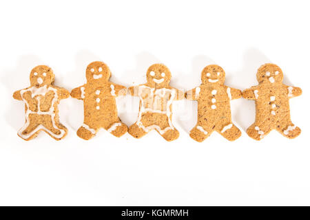 Gingerbread men cookies holding hands, on white background. Stock Photo