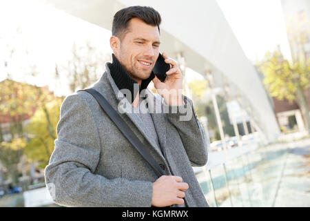 Handsome businessman talking on phone outside Stock Photo