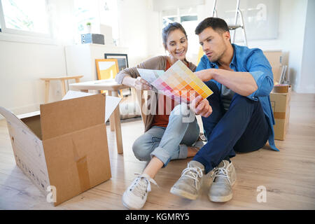 Cheerful couple moving in new home, choosing wall paint colours Stock Photo