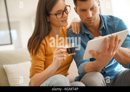 Middle-age couple websurfing on digital tablet at home Stock Photo