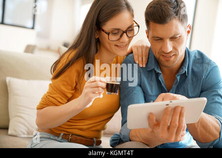 Middle-age couple websurfing on digital tablet at home Stock Photo