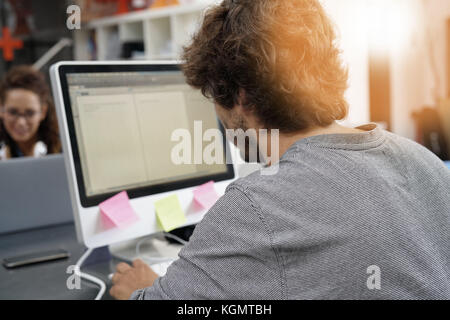 back view of man working on desktop in office Stock Photo
